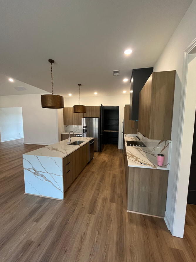 A kitchen with wooden cabinets and marble counter tops
