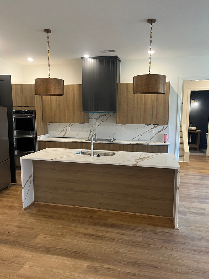 A kitchen with wooden cabinets and a large island in the middle.