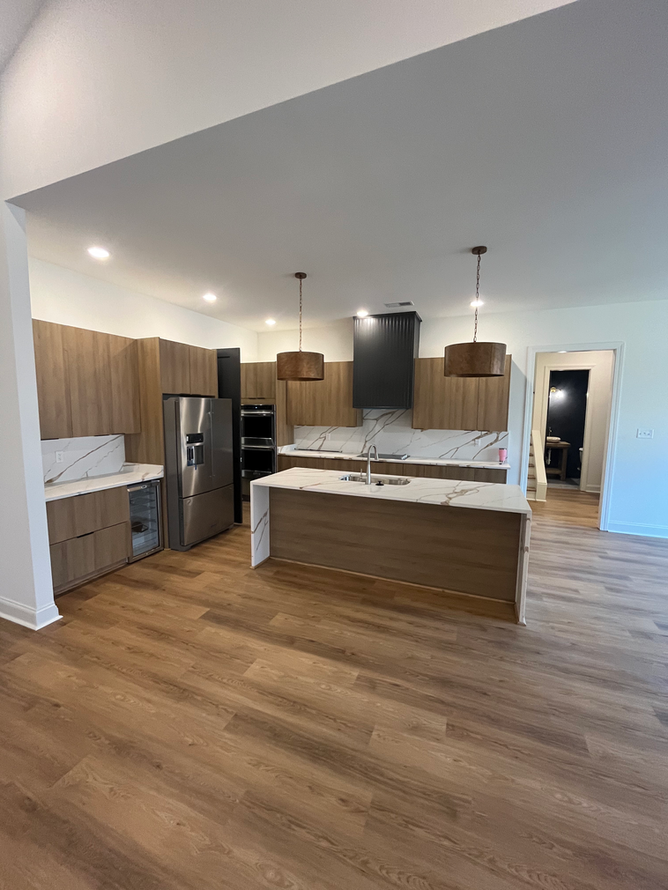 A kitchen with stainless steel appliances , wooden cabinets , and a large island.