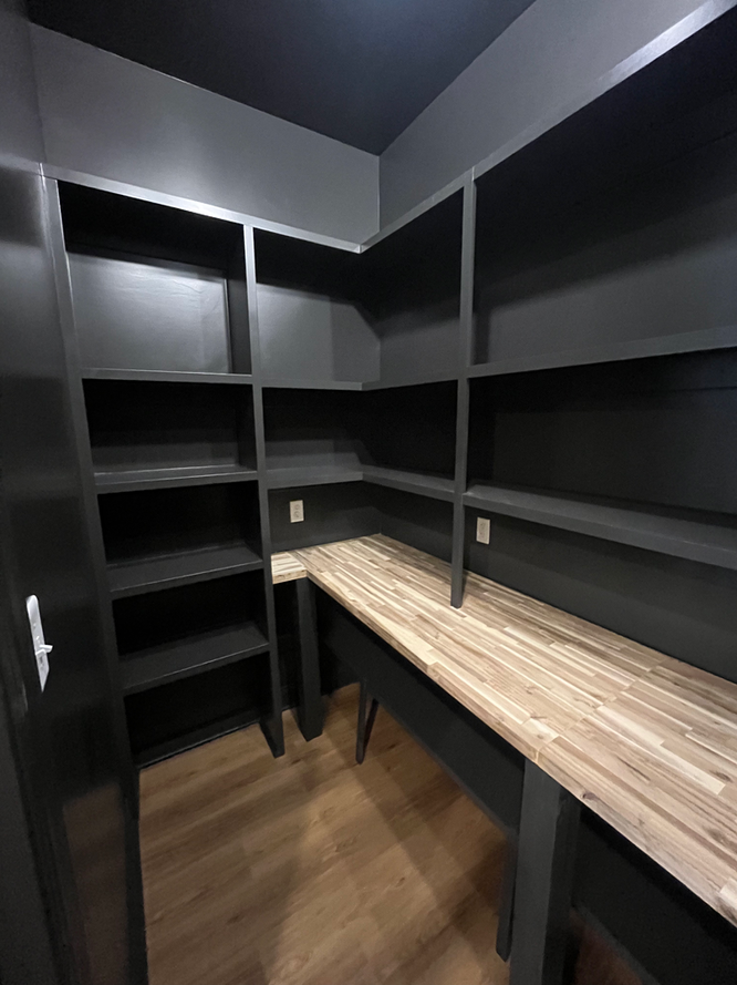 A small room with a wooden desk and shelves.