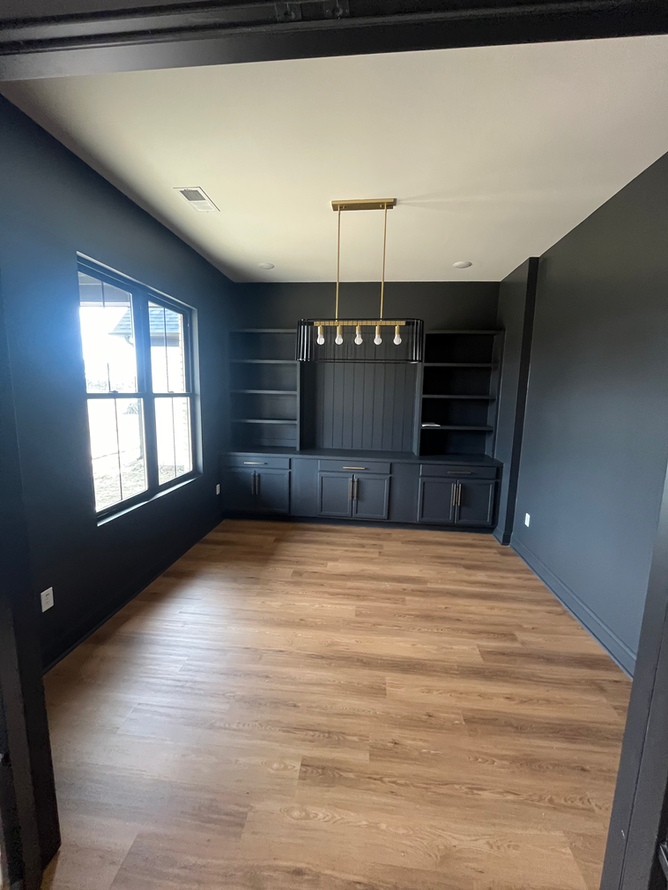 A living room with hardwood floors and black walls