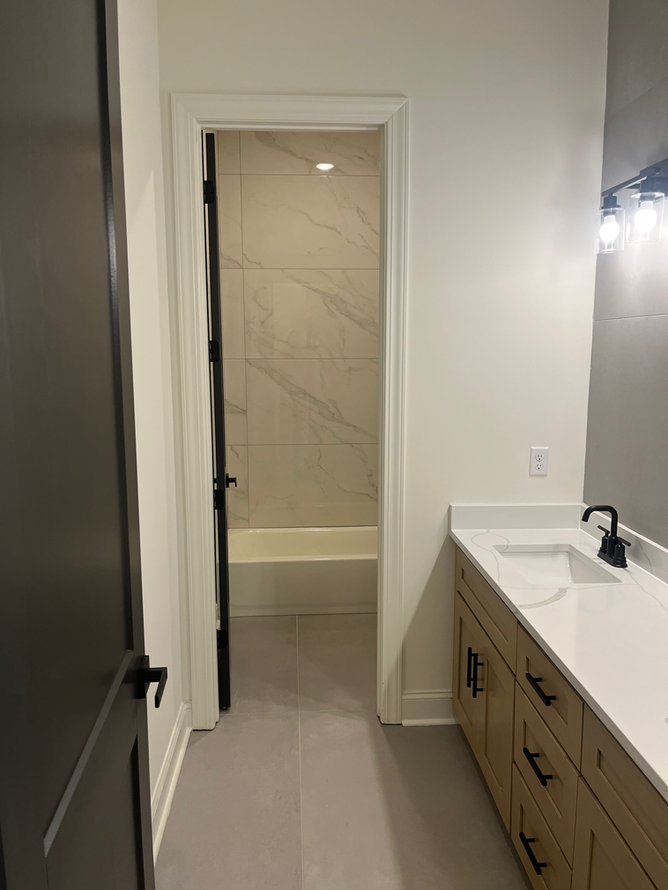 A bathroom with a sink , mirror and shower.
