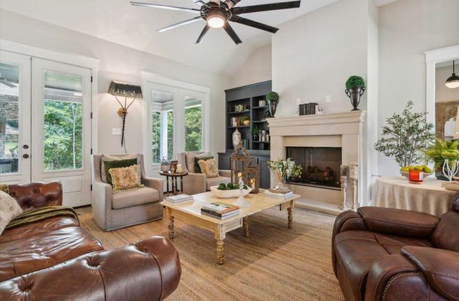 A living room filled with furniture and a fireplace with a ceiling fan.