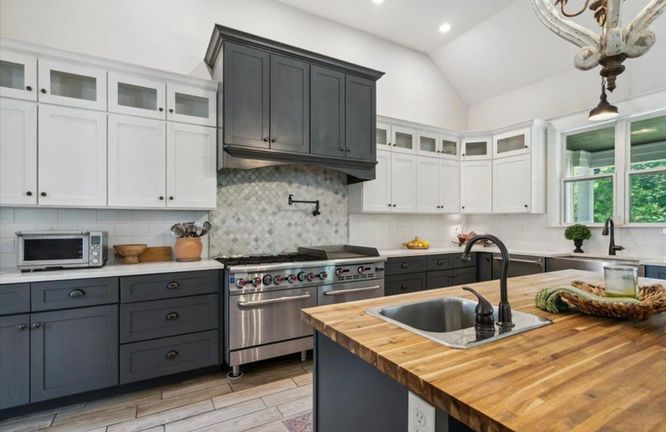 A kitchen with stainless steel appliances and wooden counter tops.