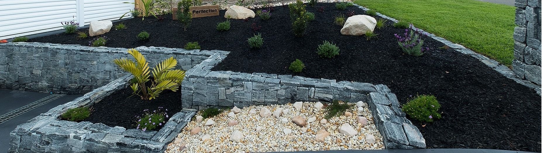 A Landscaped Garden Bed With a Stone Retaining Wall — Total Perfection In Kariong, NSW