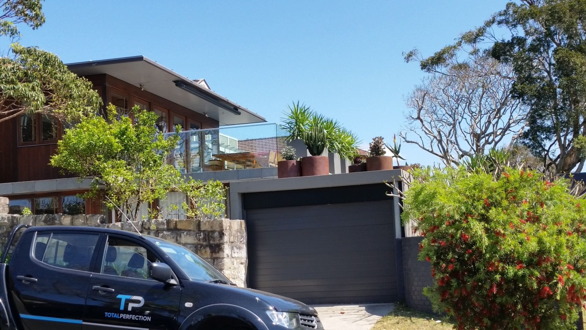 Modern House With Dark Garage and Potted Plants — Total Perfection In Kariong, NSW
