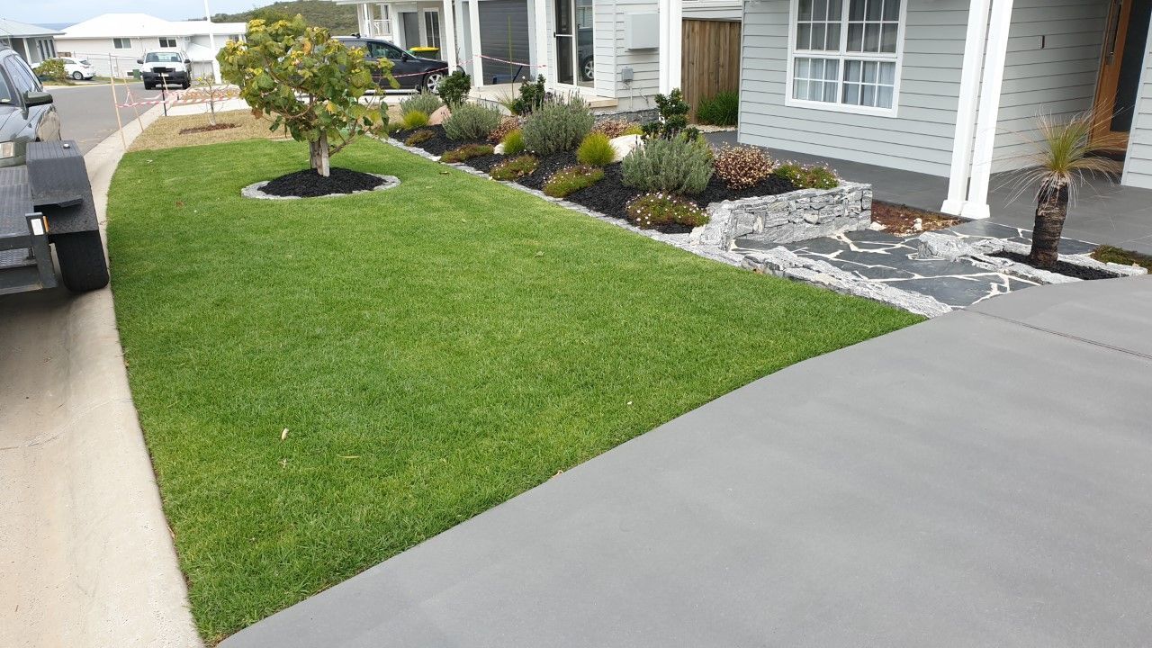 Lawn and Landscaped Front Yard Next to A Gray Concrete Driveway — Total Perfection In Avoca Beach, NSW