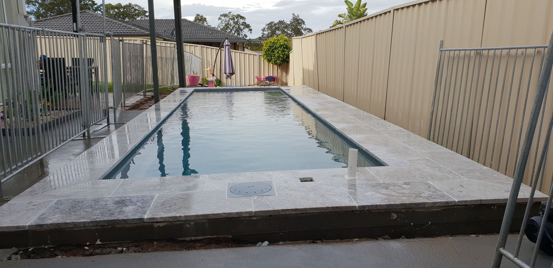 A Swimming Pool Surrounded by a Concrete Deck and a Wall — Total Perfection In Kincumber, NSW