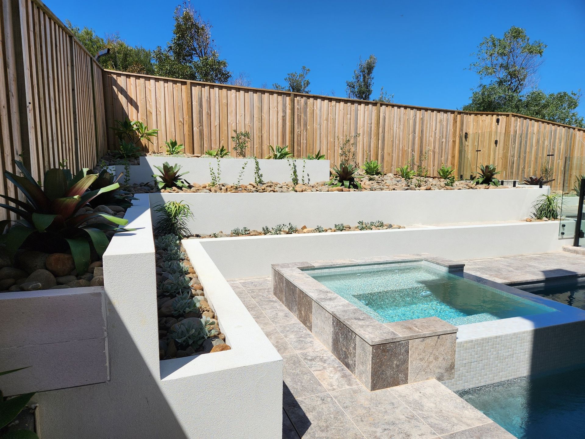 Hot Tub and Tiered Landscaping With a Wooden Fence — Total Perfection In Bateau Bay, NSW