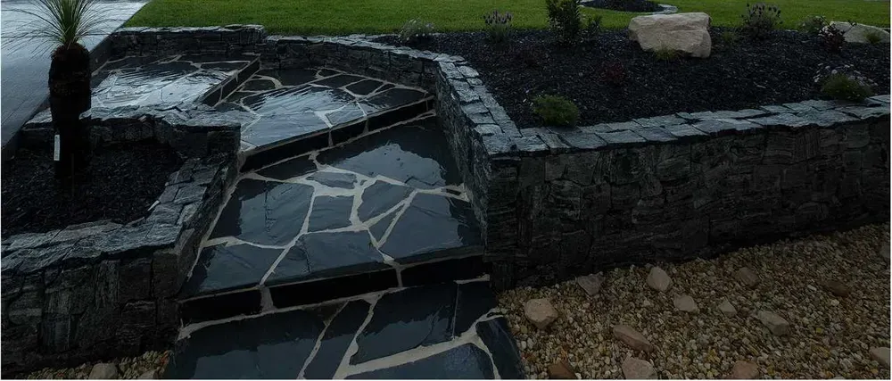 Stone Pathway and Retaining Wall With Black Mulch — Total Perfection In Catherine Hill Bay, NSW