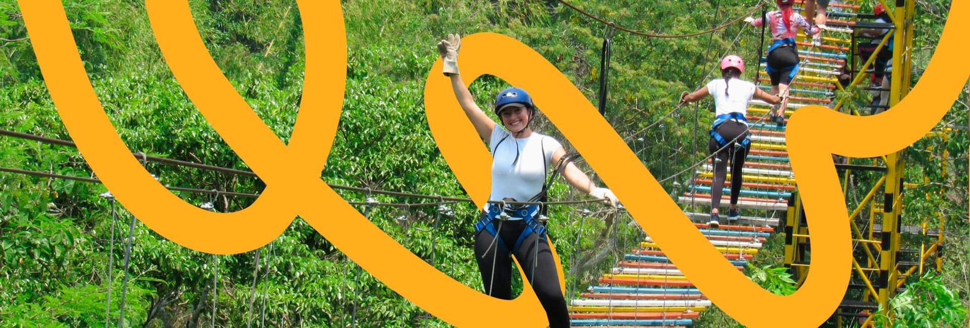 Mujer con equipo de seguridad en un puente entre árboles. Otras personas caminan detrás de ella. Líneas amarillas superponen la imagen.
