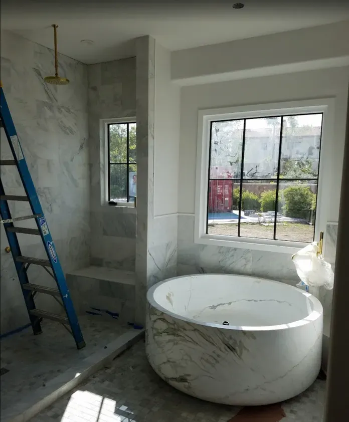 A bathroom with a round tub and a window