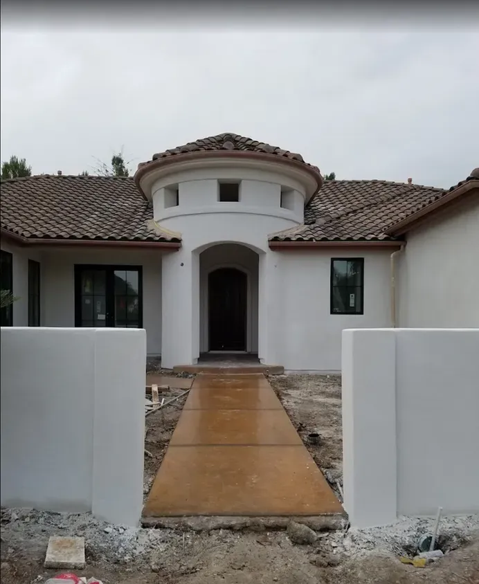 A white house with a tiled roof is under construction