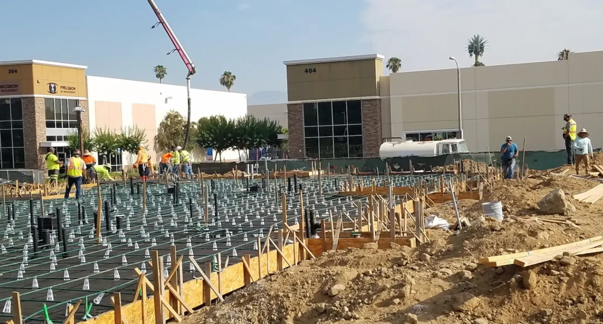 A construction site with a large building in the background.