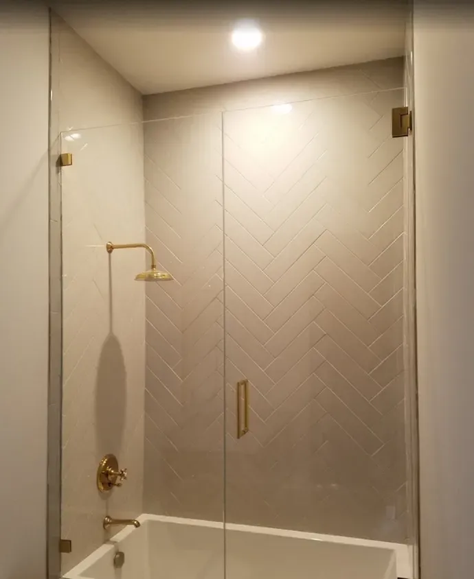 A bathroom with a bathtub and a shower with a glass door.