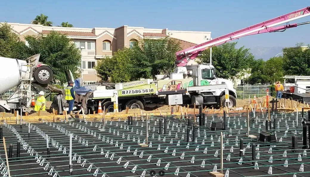 A concrete pump is being used to pour concrete on a construction site.