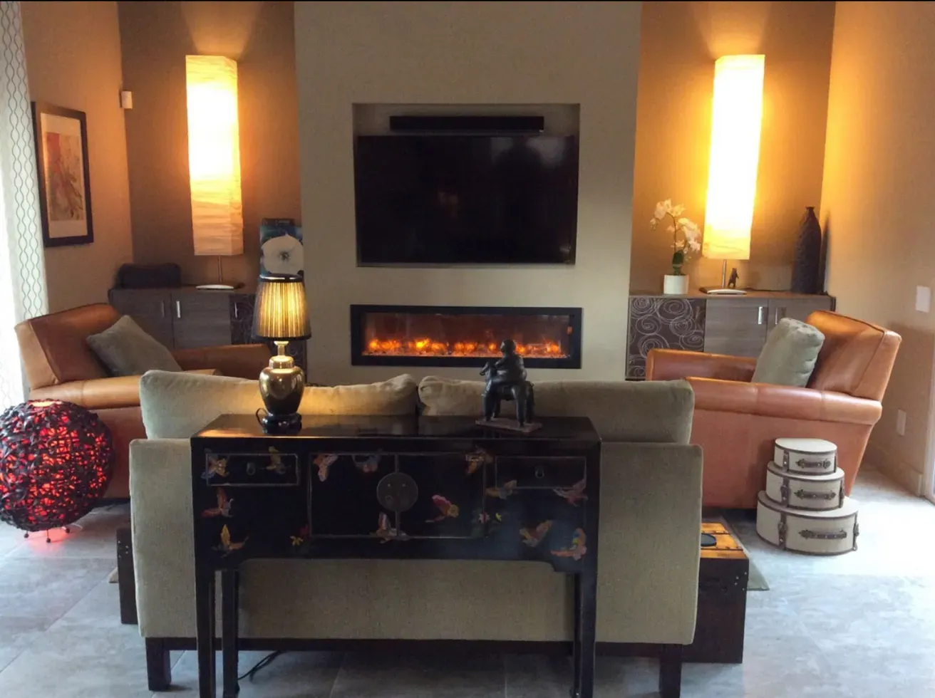 A living room with a fireplace and a flat screen tv
