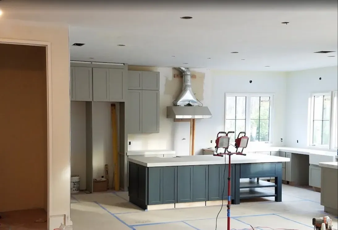 A kitchen under construction with a large island in the middle of the room.