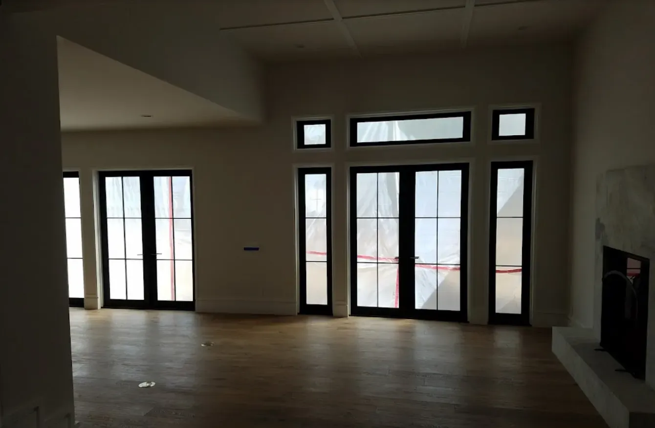 An empty room with lots of windows and a fireplace