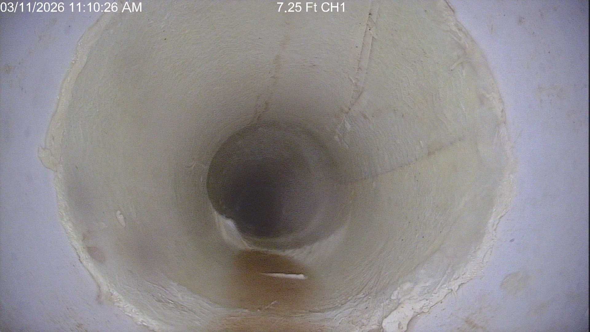 PVC pipe repair in a sandy trench. Tools, including a hammer and pliers, are nearby.