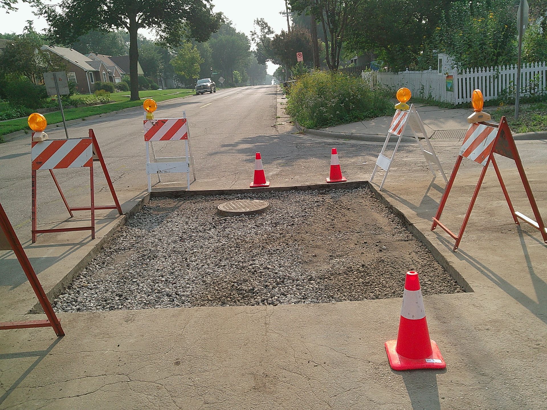 Road construction site with barriers, cones, and flashing lights.