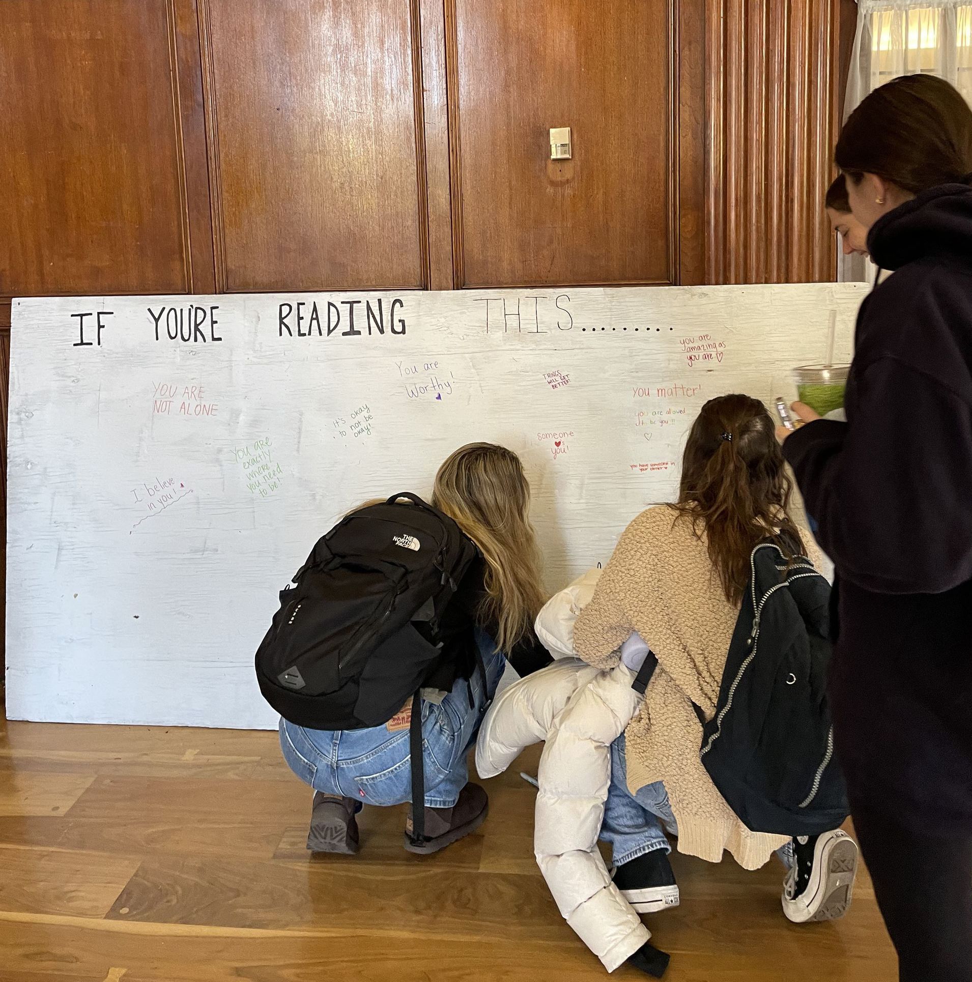 Conference participants write on a whiteboard 