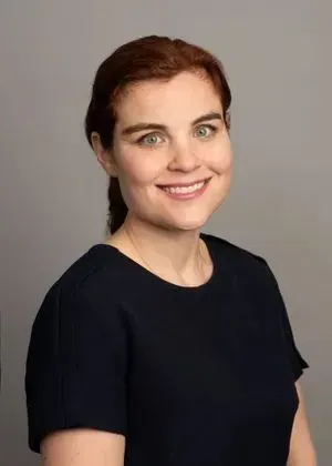 A woman in a black shirt is smiling for the camera.