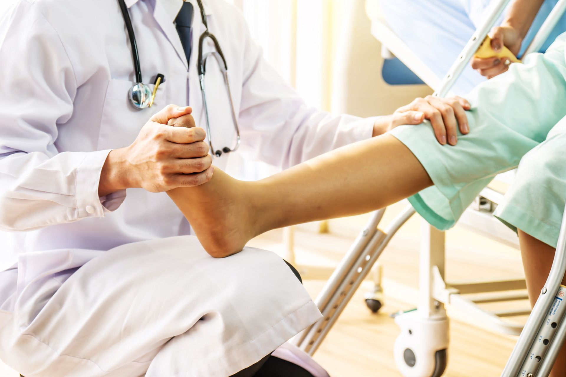 A doctor is examining a patient 's foot in a hospital.