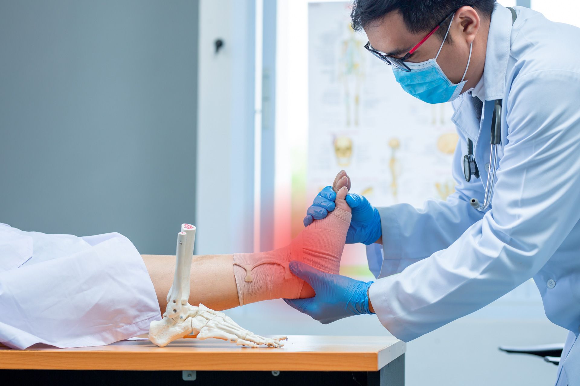 A doctor is examining a patient 's foot with a skeleton in the background.