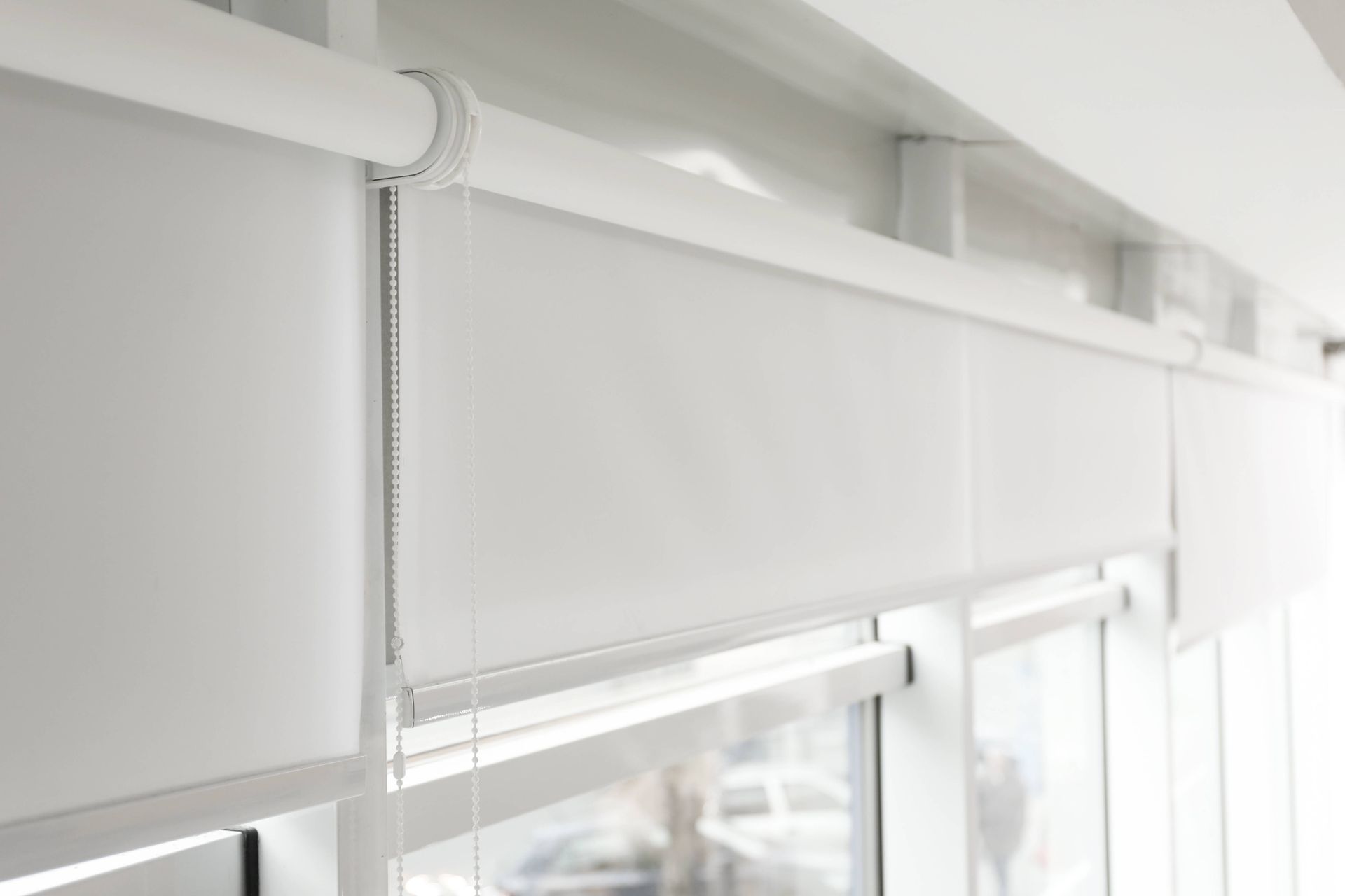 White modern roller shades covering 3 windows near St. Louis Park, MN