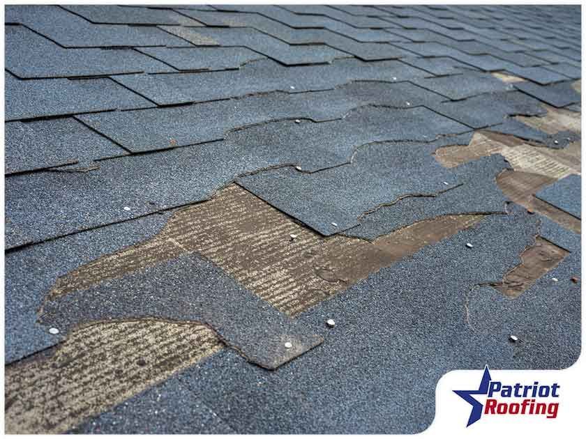 A close up of a roof with a patriot roofing logo in the corner
