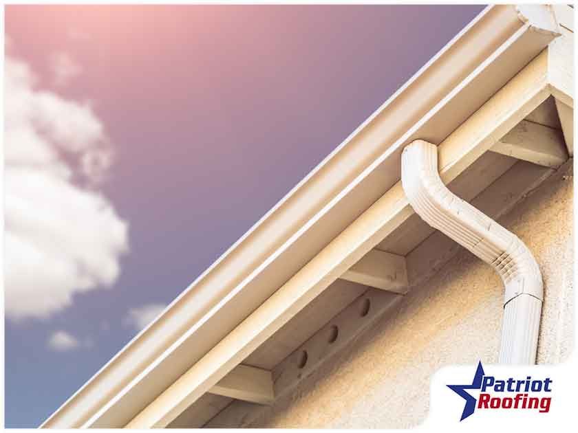 A picture of a gutter with patriot roofing in the corner