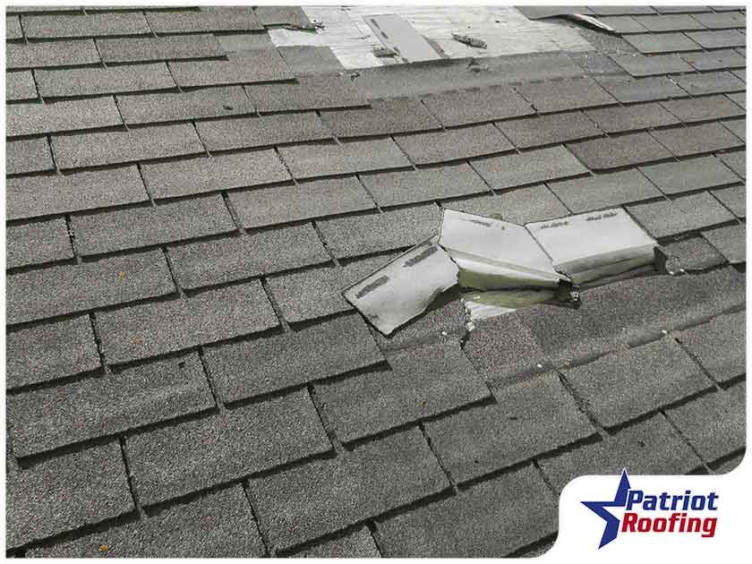 A picture of a roof with a patriot roofing logo in the corner