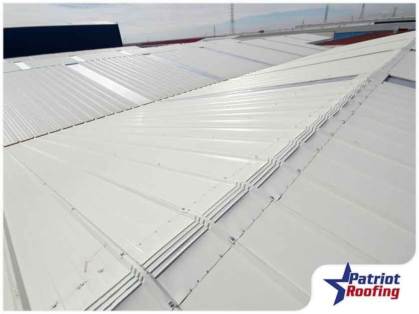 A white roof with a patriot roofing logo in the corner