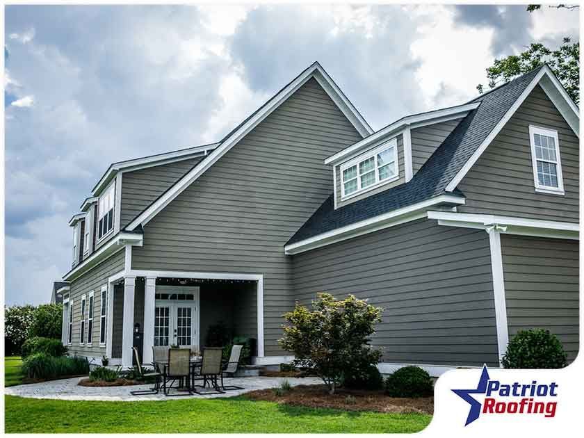 A large house with a patriot roofing logo in the corner