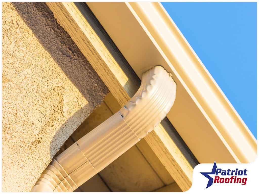 A picture of a gutter with patriot roofing in the corner