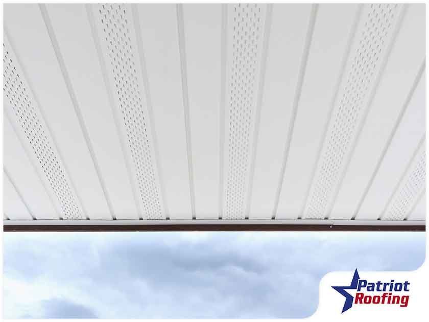 A white ceiling with a patriot roofing logo in the corner