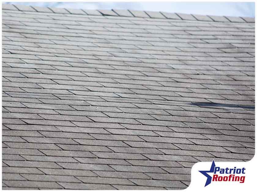 A roof with a patriot roofing logo in the corner