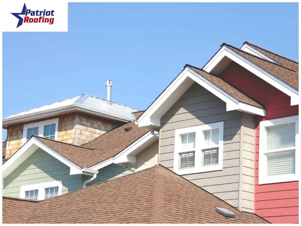 A row of houses with patriot roofing in the background