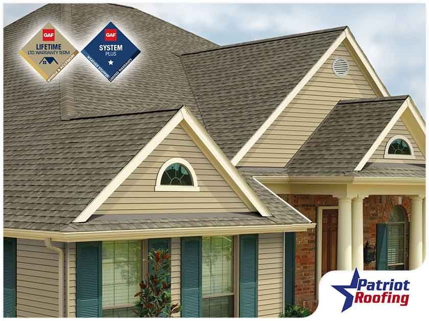 A picture of a house with a patriot roofing logo in the corner