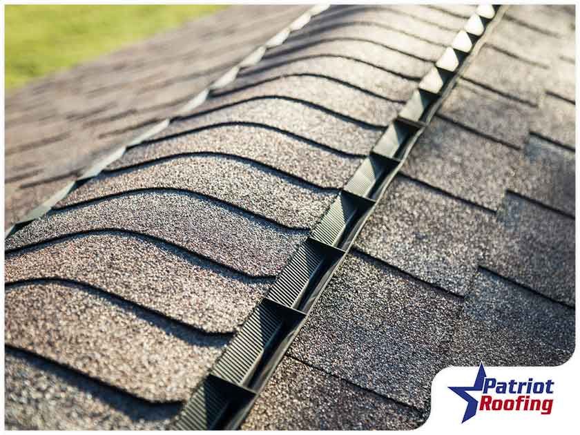 A close up of a roof with patriot roofing in the corner
