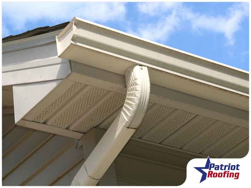 A picture of a gutter with patriot roofing in the corner