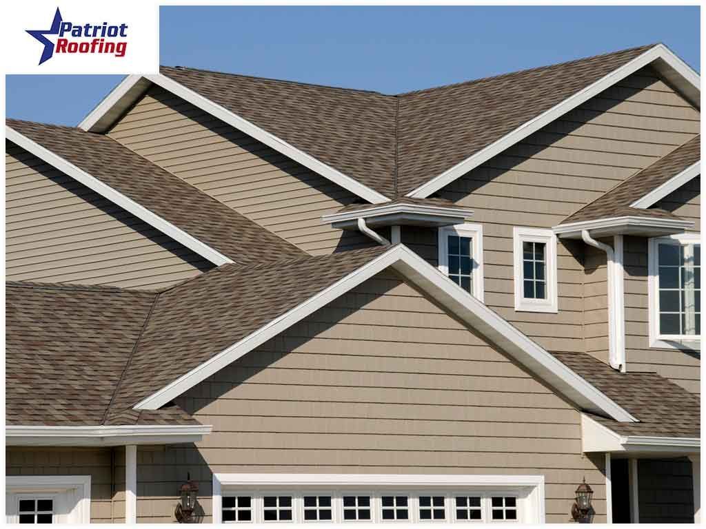 A house with a patriot roofing logo in the corner