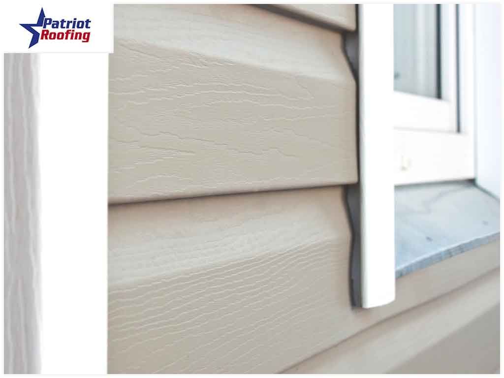 A picture of a house with siding and a window.