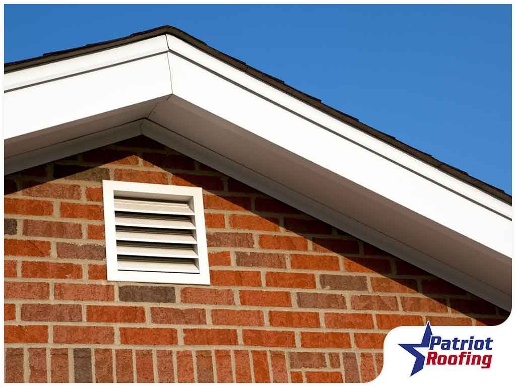 A picture of a brick building with a patriot roofing logo