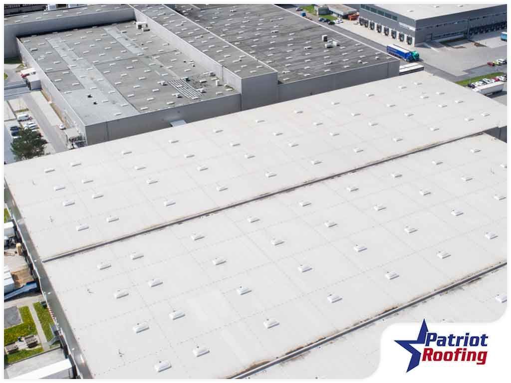 An aerial view of a large warehouse with a white roof.