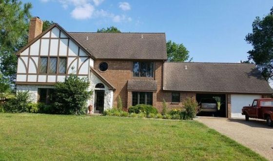 A large house with a red truck parked in front of it