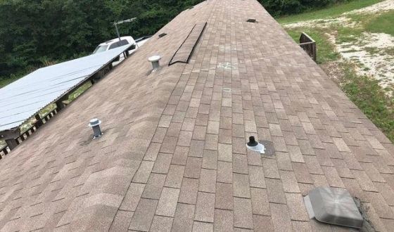 A roof with a lot of shingles on it is being repaired.