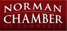 A red sign that says norman chamber of commerce