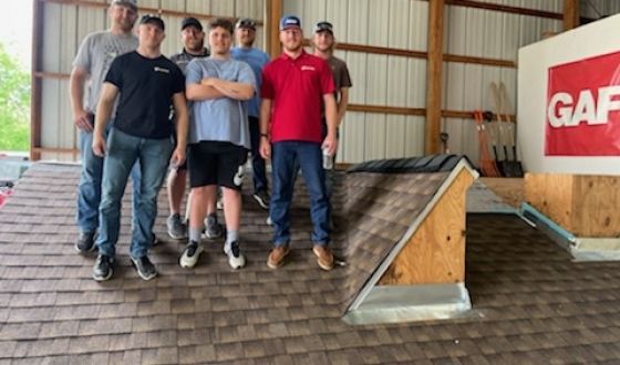 A group of men are standing on top of a roof.